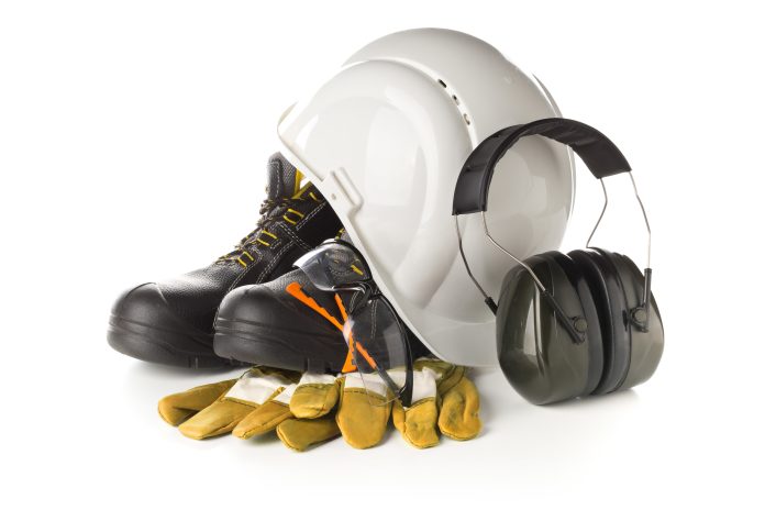 Work safety and protection equipment - protective shoes, safety glasses, gloves and hearing protection over white