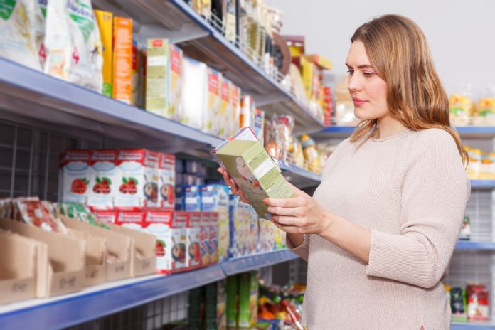 Smiling woman buyer with assortment of grocery food store
